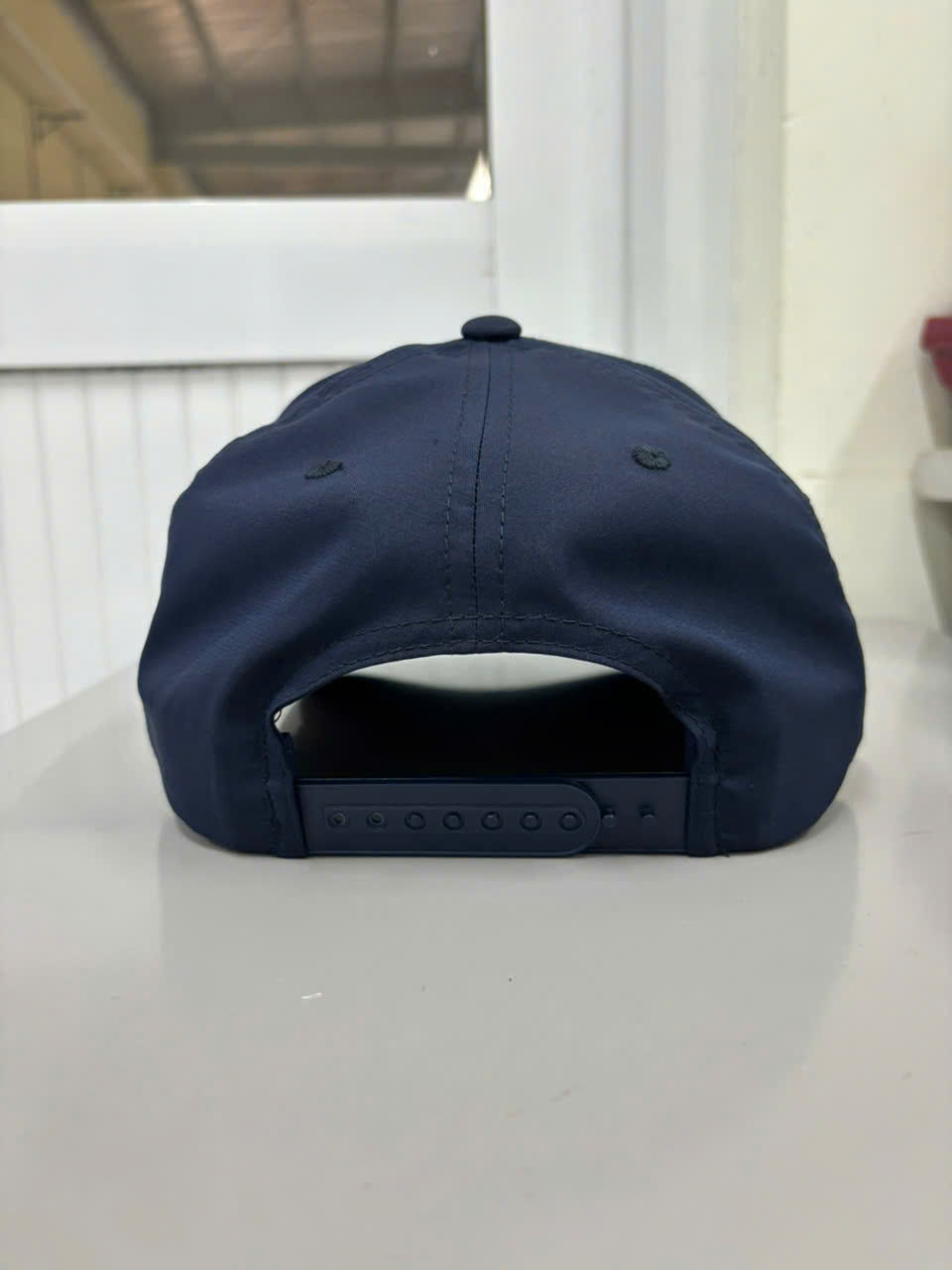 Back view of Injae Vina navy snapback golf cap with adjustable closure