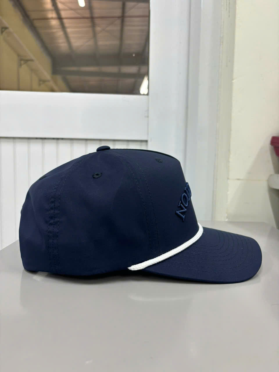 Right side view of navy Injae Vina golf cap with white rope brim detail