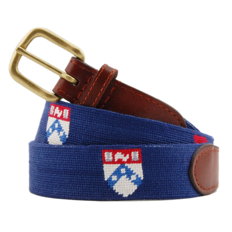 Navy blue university crest needlepoint belt with brass buckle and brown leather tab