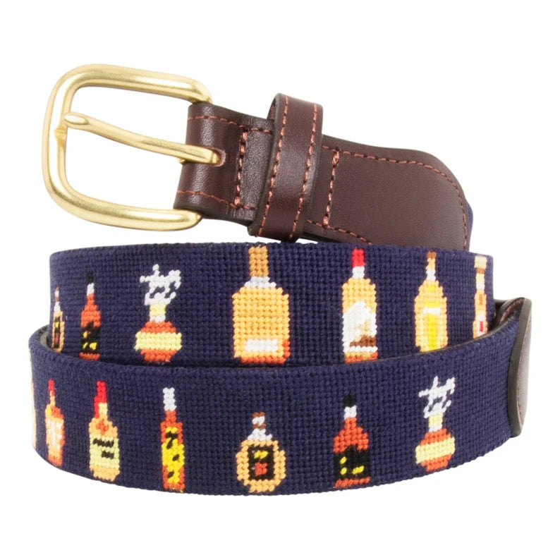 Whiskey bottles needlepoint belt coiled upright view with antique brass buckle detail